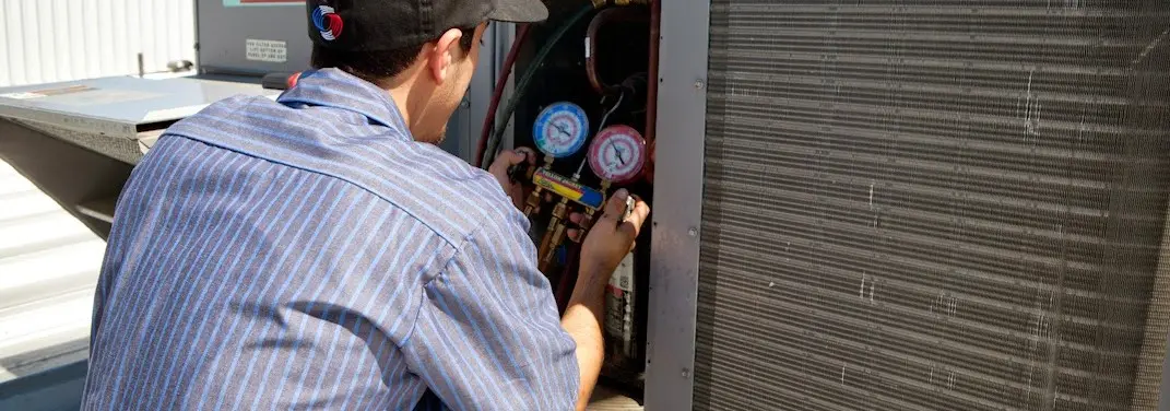 HVAC technician servicing a condenser unit in Old Saybrook